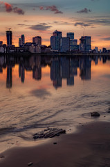 Colorful sunset over Canary Wharf, London skyline.