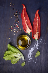 Salad ingredients: red pepper, lettuce, olive oil on rustic wooden background. Fresh vegetables, top view.