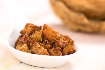 Peruvian coconut sweets sold usually on the streets, made of coconut pieces and brown sugar, which gives the sweet its brown color (Selective Focus, Focus on the sweets on the top)