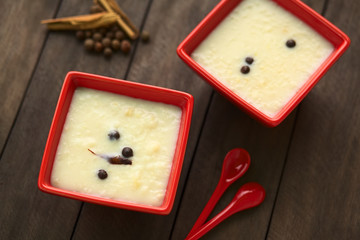 Ecuadorian dessert called morocho (coarsely ground white corn) cooked with milk, sugar and spices (Selective Focus, Focus on the cinnamon stick in the lower bowl)