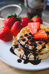 healthy breakfast waffle with strawberry  and chocolate syrup on