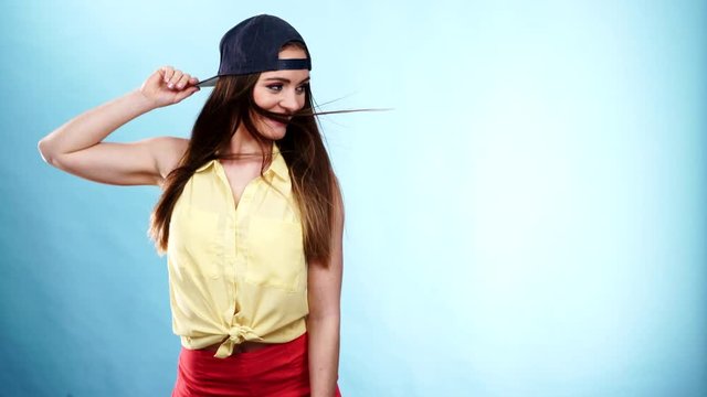 Woman casual style cap on head on blue. Fashion shot 4K