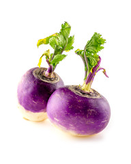 Two purple turnips with leafy tops isolated on white