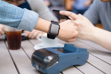 Woman pay by smart watch on pos machine