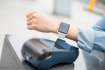 Woman paying the bill by smart watch
