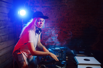 Cute dj woman having fun playing music at club party