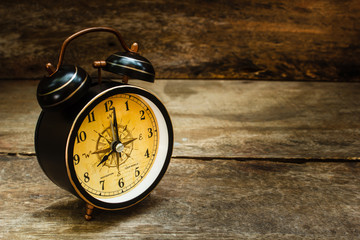 Still life with alarm clock on wood table.