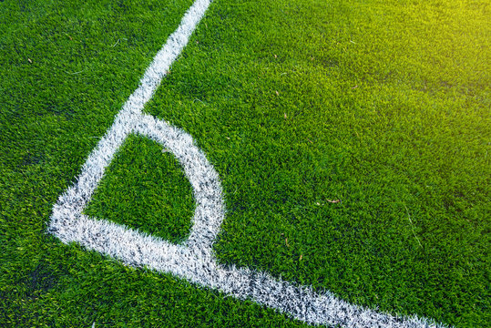 Top down angle view of white line on a green soccer field.