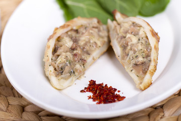 Plate of stuffed cuttlefish inside cheese, mushroom and seafood serving with aubergine salad