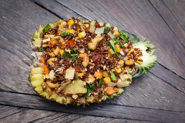 Cooked brown rice with vegetables and tofu in a pineapple