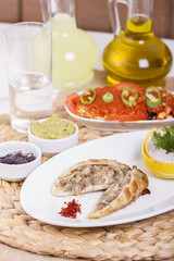 Plate of stuffed cuttlefish inside cheese, mushroom and seafood serving with aubergine salad
