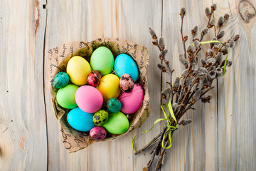 Colorful Easter eggs in the basket with willow branches