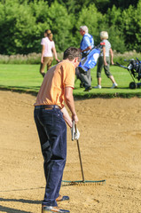Golfer bei der Platzpflege im Bunker