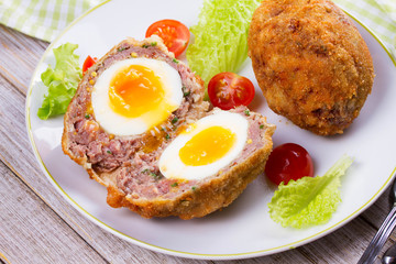 Scotch Eggs Served with Tomato Cherry and Salad on White Plate