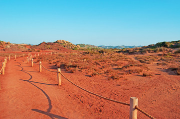 Minorca, isole Baleari, Spagna: la sabbia rossa sul sentiero per Cala Pregonda, la baia simile al pianeta Marte, il 15 luglio 2013