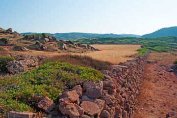 Minorca, isole Baleari, Spagna: sabbia rossa e campi di grano sul sentiero per Cala Pregonda, la...