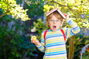 Little kid boy with apple on way to school