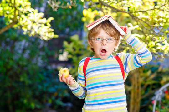 Little kid boy with apple on way to school