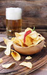 Chips in a wooden bowl and beer