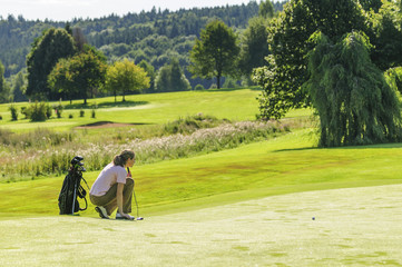 Junge Frau liest das Grün auf dem Golfplatz
