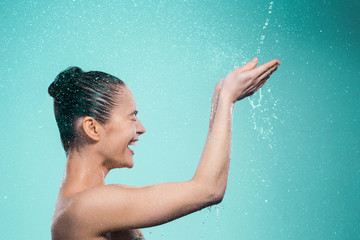 Woman enjoying water in the shower under a jet