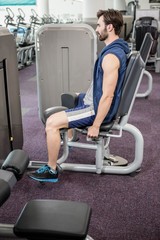 Focused man using weights machine for legs