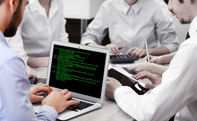 Man using laptop, writing programming code on laptop