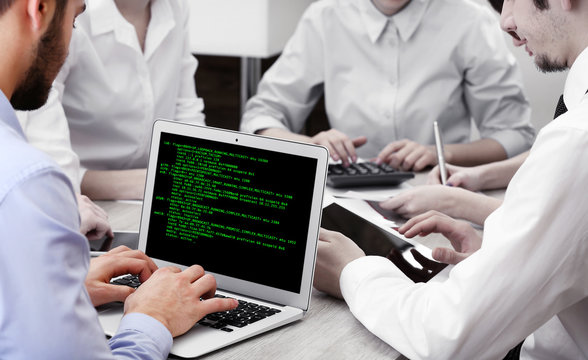 Man using laptop, writing programming code on laptop