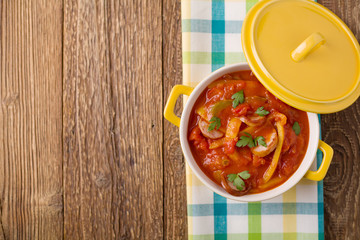 Delicious letcho with fresh vegetables, served in a yellow pot w