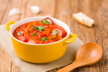 Delicious letcho with fresh vegetables, served in a yellow pot w