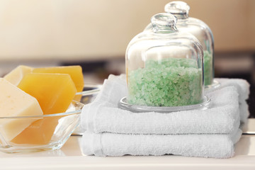 Green salt with towels and soap on a shelf in bathroom