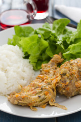 rabbit with sauce,  boiled rice and salad on white plate