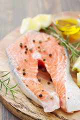 raw salmon with lemon and rosemary on wooden board