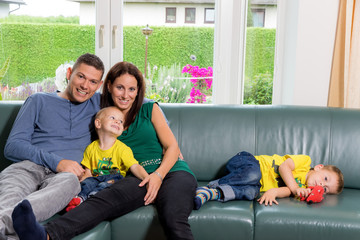 Familie sitzt auf einer Couch