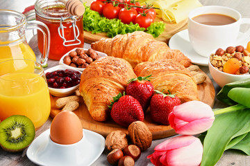 Fototapeta na wymiar Breakfast consisting of croissants, coffee, fruits, orange juice
