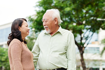 Senior Vietnamese couple standing outdoors