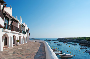 Minorca, isole Baleari, Spagna: il villaggio di pescatori di Binibeca Vell il 10 luglio 2013. Il villaggio bianco fu progettato dall’architetto spagnolo Antonio Sintes nel 1972 - obrazy, fototapety, plakaty