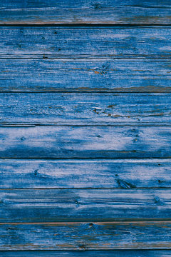 Old blue cracked paint on the old wooden background