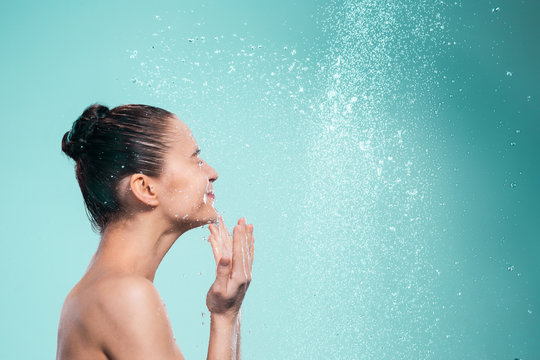Woman enjoying water in the shower under a jet