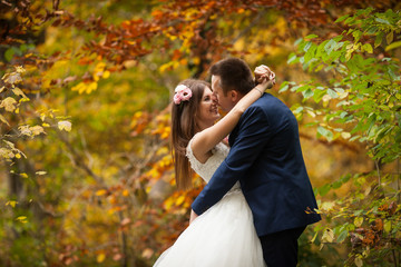 elegant stylish groom with his happy gorgeous brunette bride on