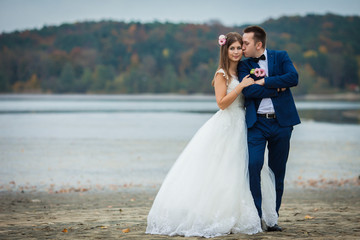 elegant stylish groom with his happy gorgeous brunette bride on