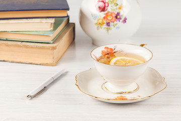 Tea with  lemon and books on the table