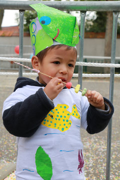 Petit gar&ccedil;on mangeant une brochette de bonbons