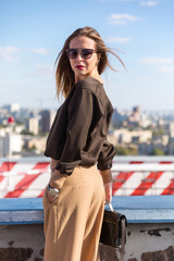 Fashion  girl posing over Red white striped wall background. Beauty woman with pink lips make-up posing on the street. 