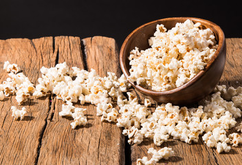 Salt popcorn, party hat and candy on the wooden table,