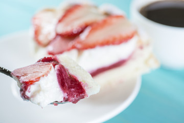 eating Pie with strawberries and cream on a spoon, shallow dof
