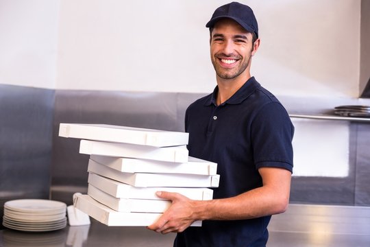Pizza delivery man carrying boxes - Powered by Adobe