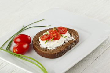 slice of bread with creamy butter and tomato slices