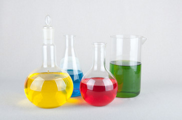 Four laboratory flasks with liquid