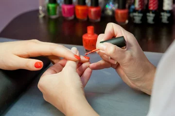 процесс маникюра,покрытие ногтя красным лаком,крупный план